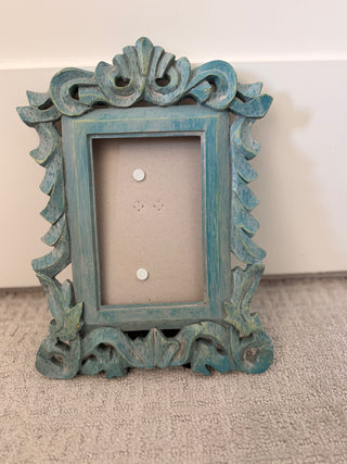 Distressed blue wooden scroll frame